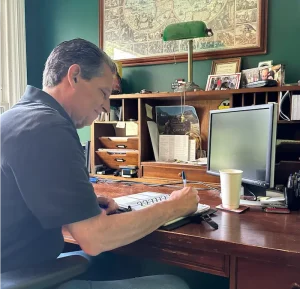 Dennis Fassett — Personally Guiding Families Through Estate Home Solutions Dennis Fassett sitting at his desk, reviewing notes from the day’s property visits, focused and thoughtful.