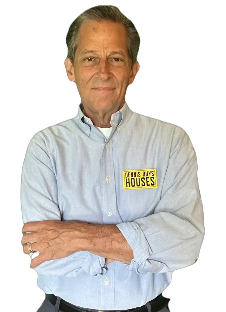 Dennis-of-Dennis-Buys-Houses Dennis with arms crossed in a blue button down featuring a “Dennis Buys Houses” logo, standing confidently on a transparent background.